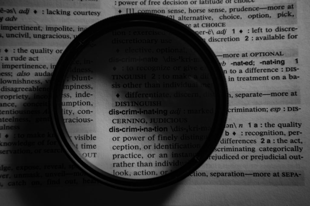 Image of a lense, highlighting the word discrimination