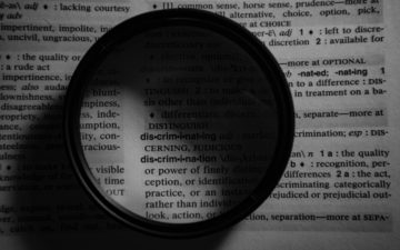 Image of a lense, highlighting the word discrimination