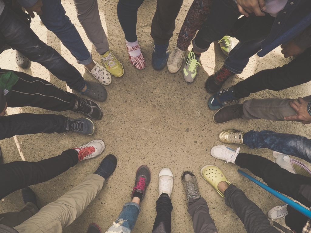 Image of a circle of feet with shoes of all kinds.