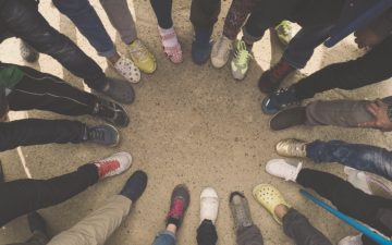 Image of a circle of feet with shoes of all kinds.